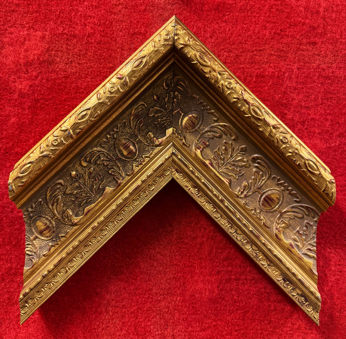 Close-up of 4 inch wide antique gold premium grade fiber material frame with ornate embossed carvings 2 inch thick